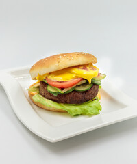 Author's burger with vegan cutlet, fresh vegetables and cheese sauce. Isolate on a white background. Vertical. Ready layout