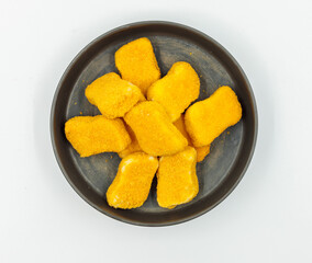 Nuggets on a black plate, top view, isolate. Layout