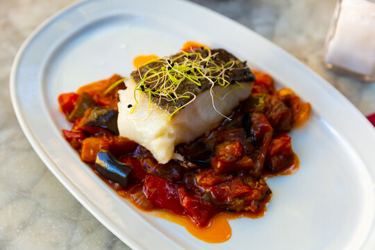 Popular dish of Spanish cuisine is Bacala, made from fish with vegetables and decorated with greenery on top