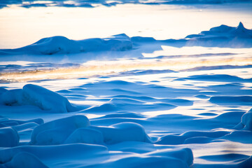 Flowing path in frozen river surrounded by ice and snow