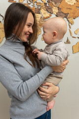 young pretty mother holds her little son in her arms, smiles, hugs. Young family, education of mother and son, emotions, hugs