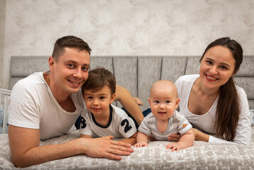 family mom dad sons sitting on the bed