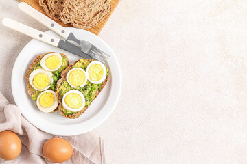 Plate of tasty toasts with boiled egg on light background
