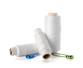 Thread spools and colorful pins isolated on white background