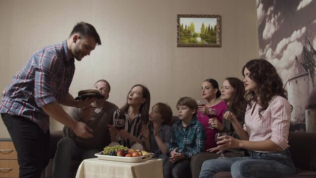 Big happy family sitting on a couch by the small table with fruit plate. Stock. Celebration at home with children.