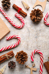 Composition with sweet candy canes and cones on light background