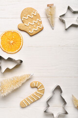 Fototapeta na wymiar Composition with Christmas decorations, cookies and cutters on light wooden background, closeup