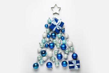 Christmas tree made of beautiful balls and gift on light background