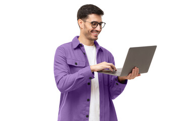 Young man wearing casual purple shirt, standing with opened laptop in hands, surfing online