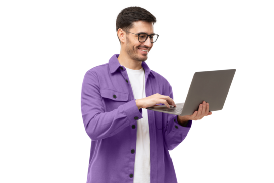 Young man wearing casual purple shirt, standing with opened laptop in hands, surfing online