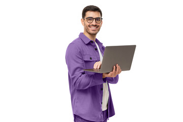 Portrait of young modern businessman standing holding laptop and looking at camera with happy smile
