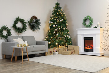 Interior of living room with Christmas wreaths, fireplace and fir tree