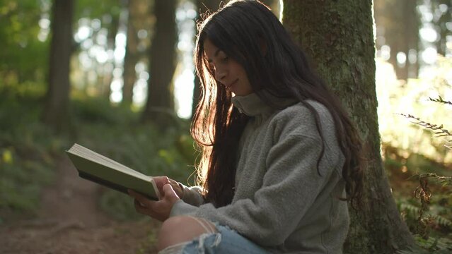 Close up of girl reading book in magical forest