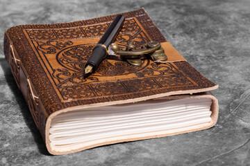 Leather journal, embossed with Celtic tree of life design, with recycled paper and fountain pen. On...