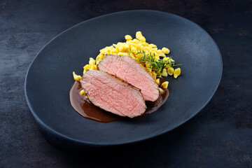 Tafelspitz Braten Scheiben vom Kalb mit schwäbische Spärtle serviert mit Dunkelbier Sauce als close-up in einem Design Teller 