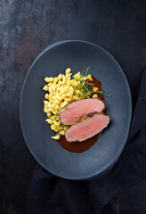 Tafelspitz Braten vom Kalb mit schwäbischen Spätzle serviert mit Dunkelbier Sauce als Draufsicht in einem Design Teller mit Textfreiraum  