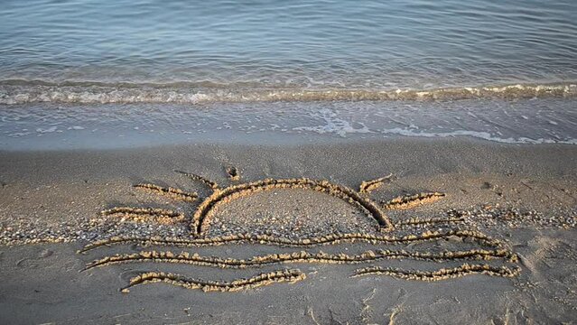 Drawing on sand. Drawing of waves and hot summer sun