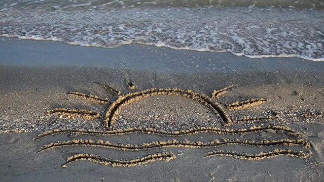 Drawing on sand. Drawing of waves and hot summer sun