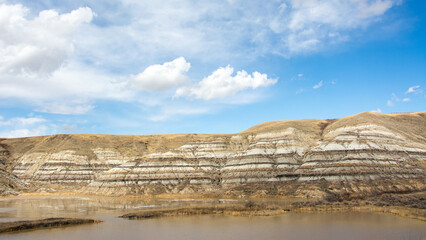Badland hills with clouds in blue sky, Alberta