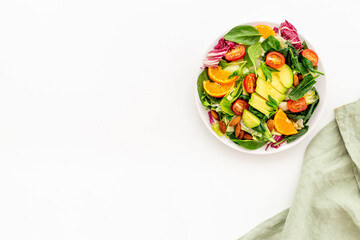 Top view of served green salad with avocado and tomatoes