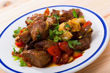 Portion of stewed beef with mushrooms, bell pepper, onion garnished with parsley