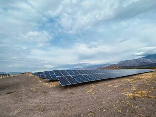 Scenic view a wide land with solar panels arranged in row under the gloomy sky