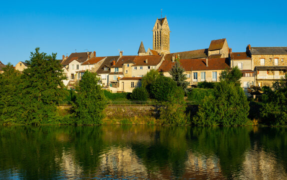 Marne river, residential buildings and local church along riverside in Dormans. Marne department, Grand Est region of France.