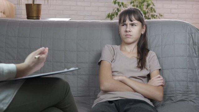 Closed child. A psychologist try to sort out the girl's problems at medial consultation in the room.