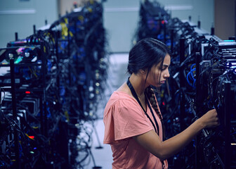Female technician working in server room