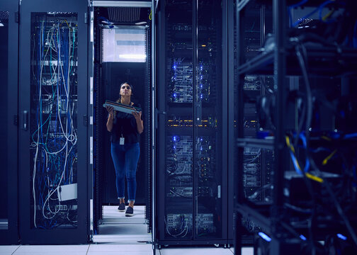 Female technician carrying hard drive in server room