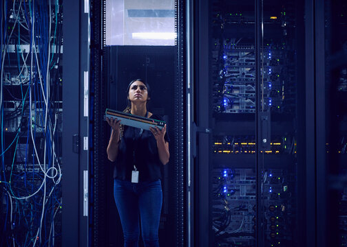 Female technician carrying hard drive in server room