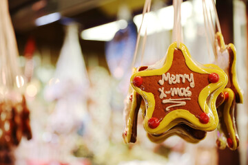 Gingerbread star shaped Christmas cookie hangs on the rope in Christmas market stall for sale