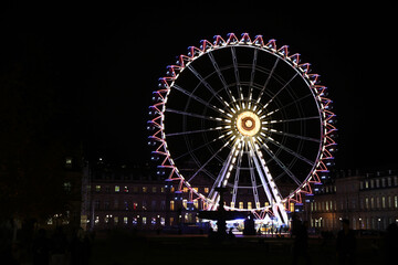 Colorfull ferris wheel at night in europe on the main square near Christmas market with soft focus