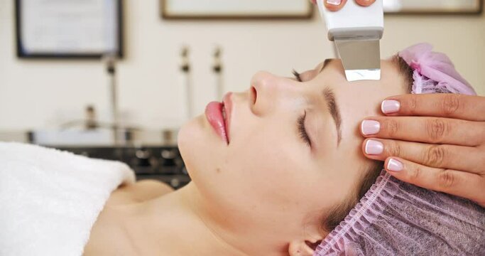 Beautiful woman receiving facial microcurrent treatment at spa salon. Beautician using electrical impulses for facial procedures. Woman in spa salon. Woman in a spa salon on cosmetic procedures.