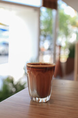 Dirty Coffee on wooden table. Espresso shot topped over cold fresh milk create a gradient layer in the morning.