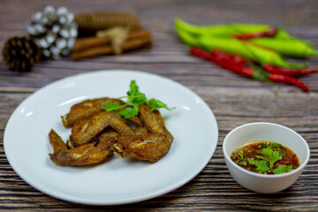 Fried Chicken Wings garlic pepper serve with spicy dipping sauce Thai style and eat with alcoholic beverages it's compatible with each other very well.
