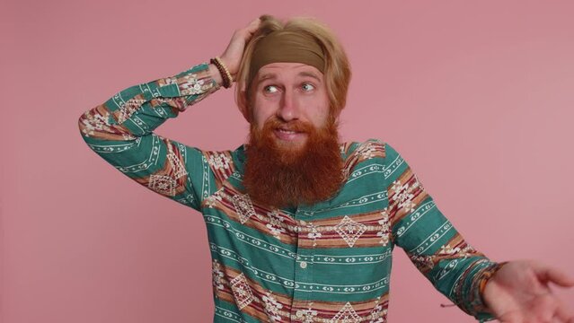 I dont know what to say. Confused hippie man feeling embarrassed about ambiguous question, having doubts, no idea, being clueless and uncertain. Young redhead hipster guy on pink studio background