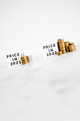 inflation and cost of living going up concept, Price in 2021 vs Price in 2022 with small and big stacks of coins side by side
