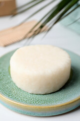 Solid shampoo bar and leaf on white table, closeup. Hair care