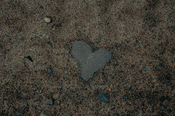 puddle on the shore of the lake in the form of a heart