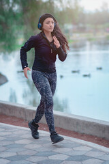 Woman running on the path of a park. Healthy lifestyle concept. Athletic sports exercises for athletic people.