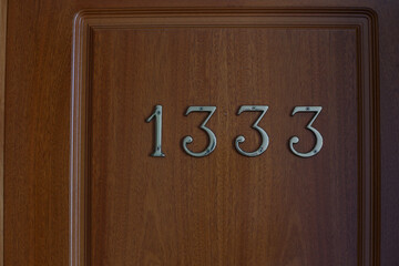 Hotel wood door, iron number 1333 , close up image.