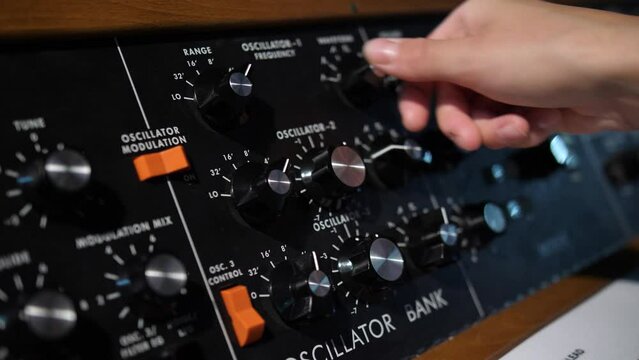Adjusting amplitude frequency dials on a oscillator analogue bank