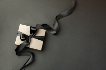 Craft gift box on a dark background, decorated with a textured bow, creating a romantic luxury...