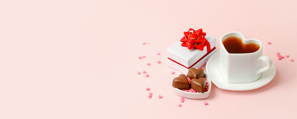 Flat lay of heart shaped cup of black coffee, gift box and candy on pink background with copy space. Valentine's day, beverage concept, Good morning, romance surprise, banner, flyer