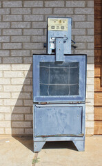Empty Newspaper Vending Machine on Sidewalk near store building