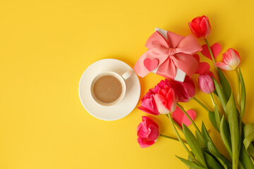 Greeting card. Bouquet of colorful tulip flowers, cup of coffee, gift box on yellow, copy space, invitation card. Spring time seasonal holiday, 8 march International woman day, Mother day, banner