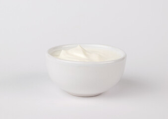 A jar with white sauce on a white background.