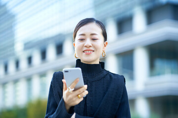 スマートフォンの画面を見る女性