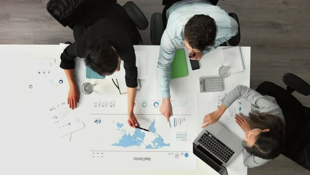 Global statistics, world map and business people meeting, analytics and data analysis, planning or strategy in marketing agency. Top view of international market, teamwork ideas and workshop research